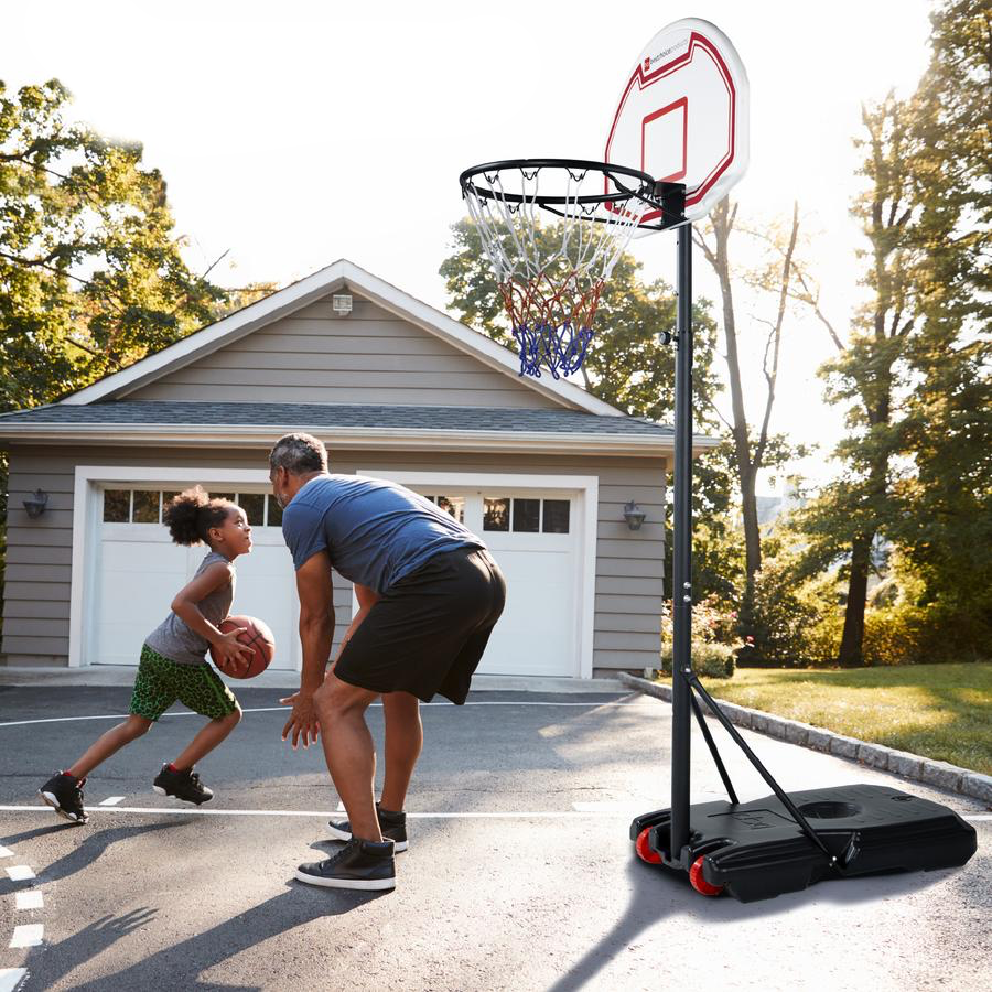 girl and a man playing basketball in a driveway