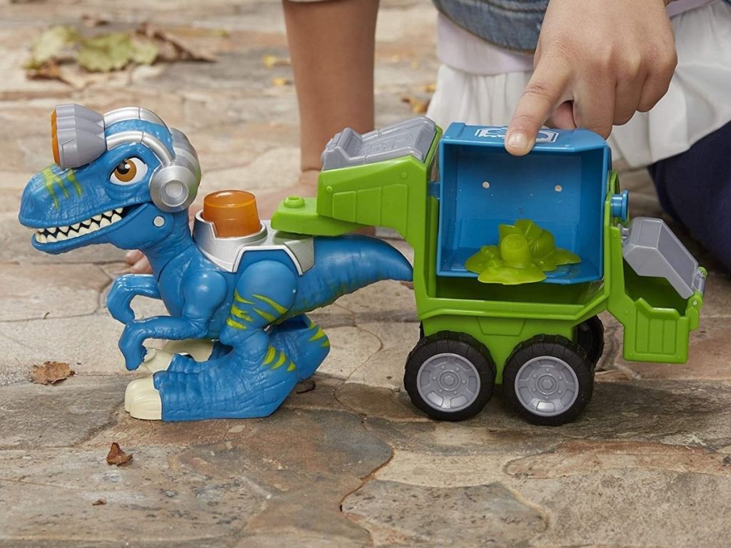 kid pushing dinosaur truck toy