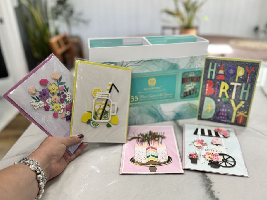 Opn box of Costco greeting cards with various cards displayed in front of it