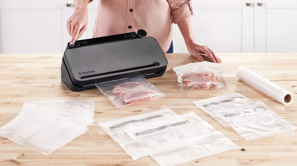 woman using foodsaver sealer on kitchen counter