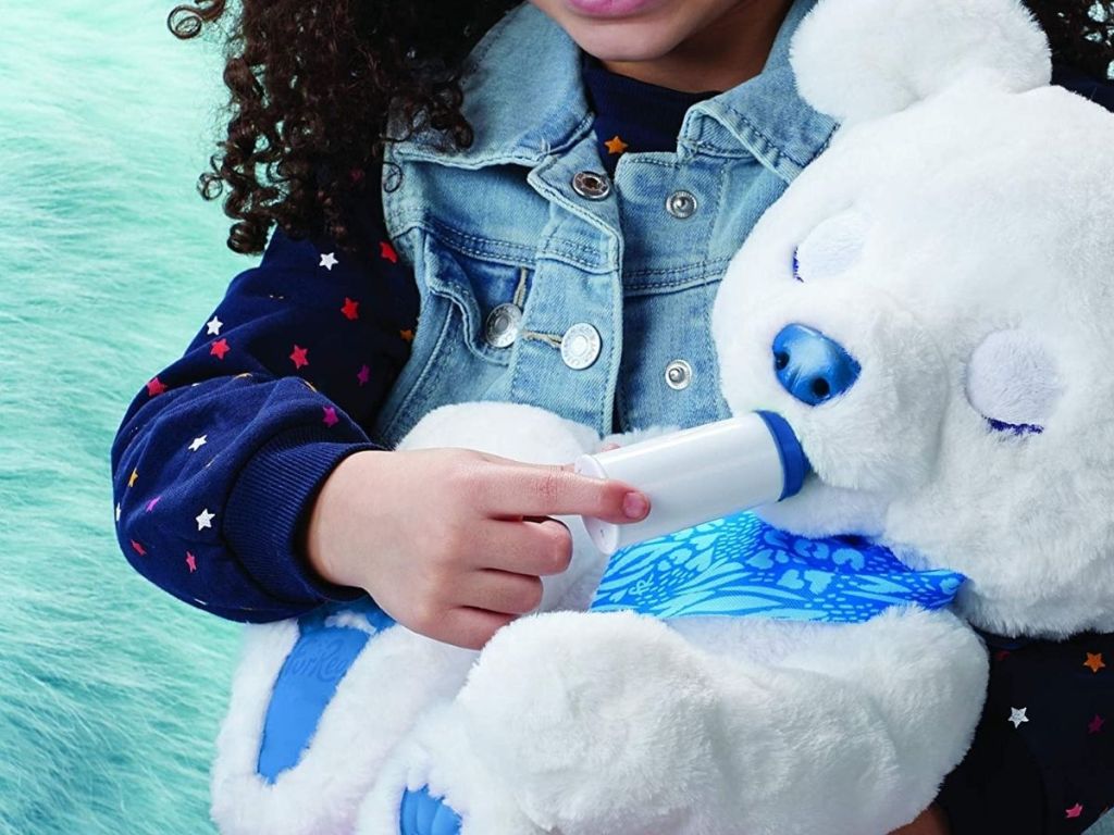 girl feeding bear with bottle