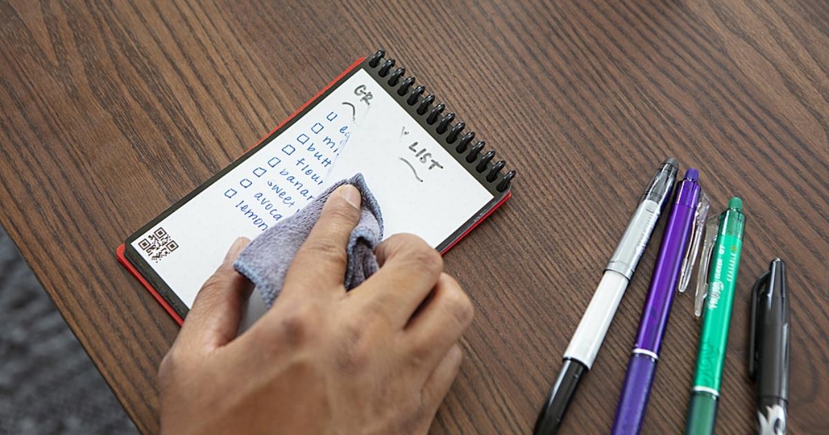 person erasing rocketbook mini reusable notebook