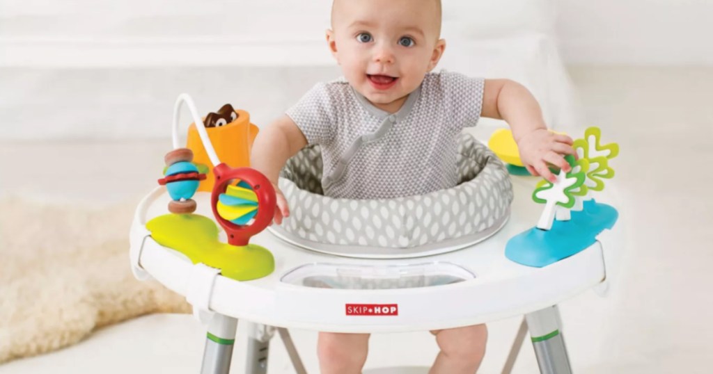 baby in gray and white activity chair 