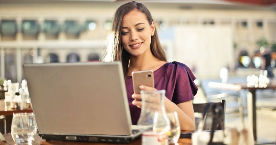 Woman using Cell Phone and Laptop