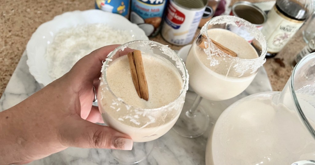 adding a cinnamon stick to coquito