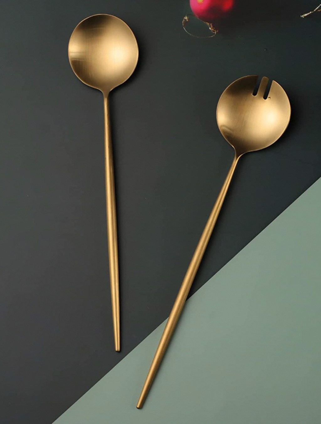 gold brass salad servers on green geometric background 