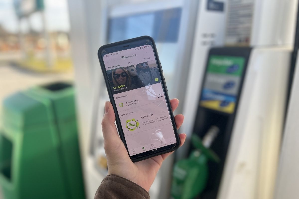 holding a cell phone in front of BP gas pump