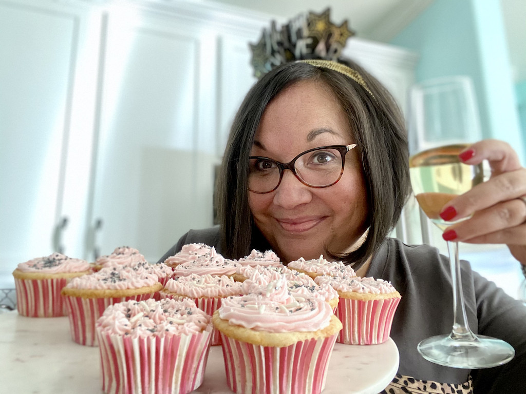 Woman holding cupcakes and drinking champaigne 