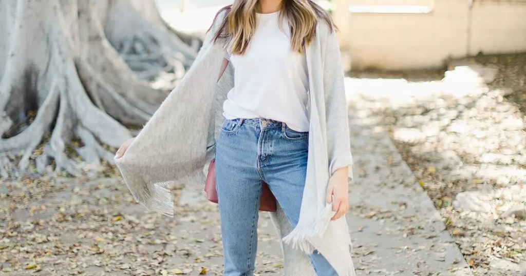 woman wearing a gray shawl and jeans