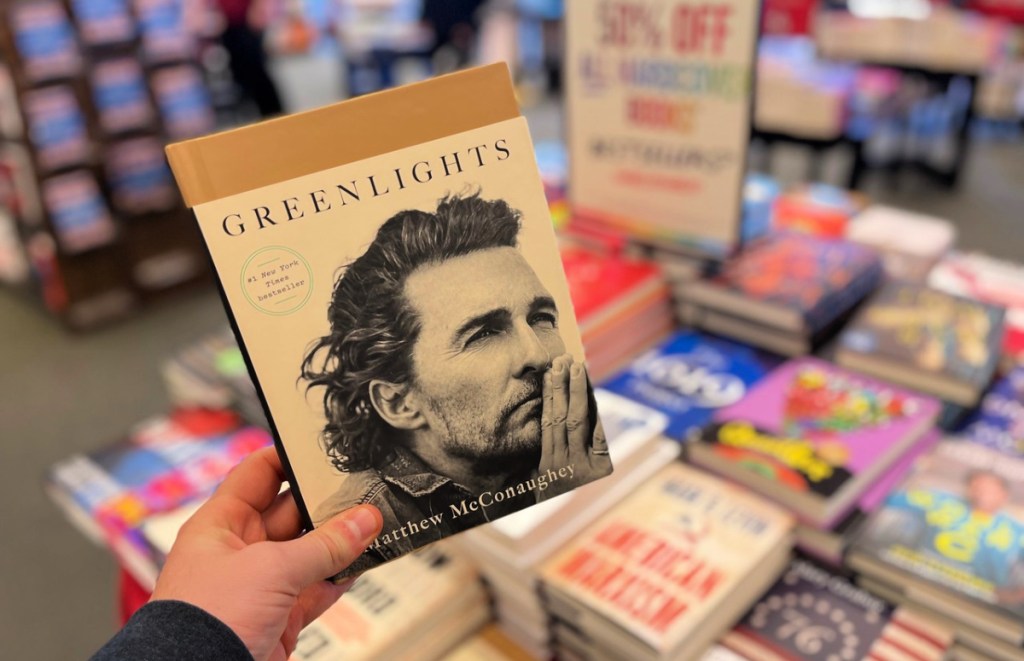 man holding greenlights hardcover book