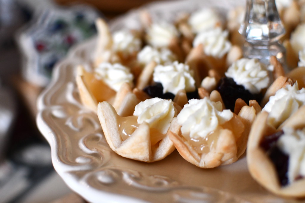 close up of mini fruit tarts with cream cheese topping 