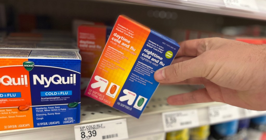 hand grabbing cold and flu medicine off shelf 