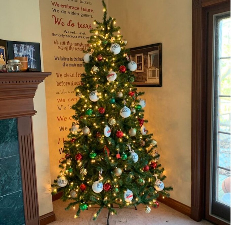 pre lit christmas tree standing in corner of living room with ornaments