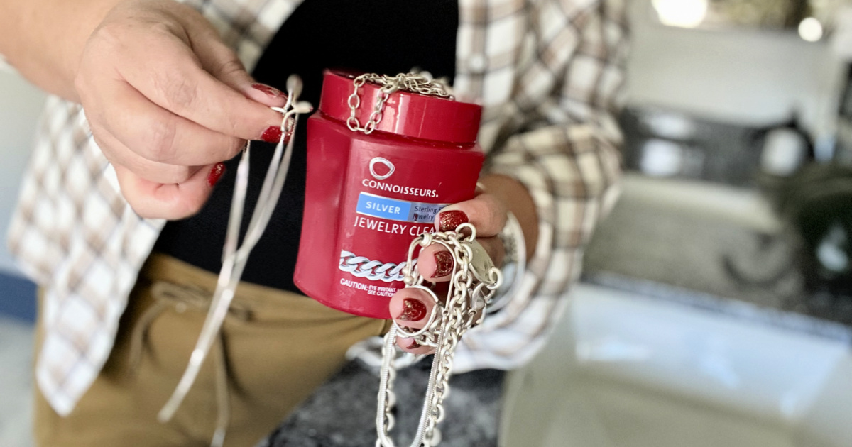 woman holding silver cleaner and necklaces showing how to clean sterling silver jewelry