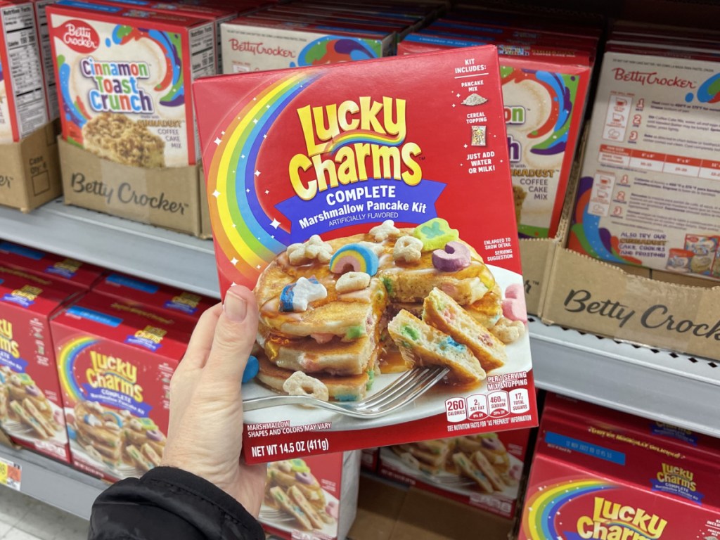 hand holding box of cereal pancake mix in store