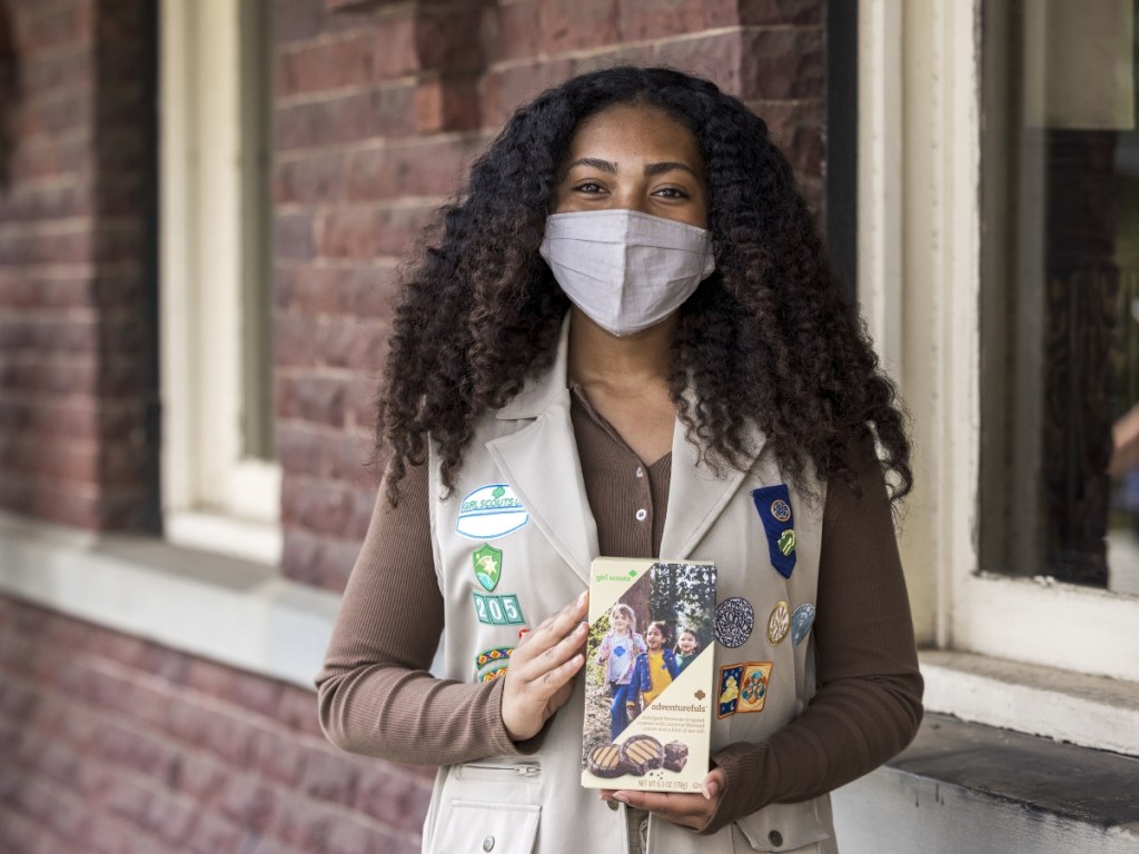 masked Girl Scout with a box of cookies