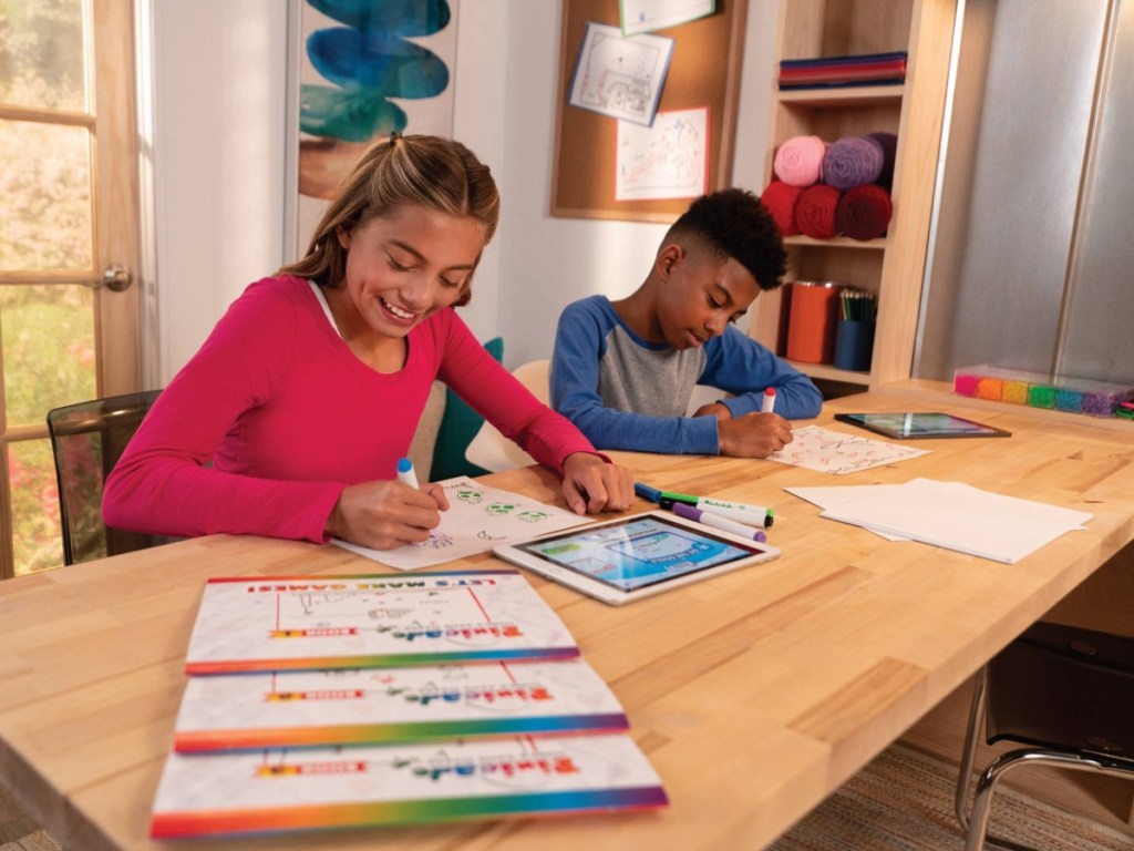 boy and girl drawing with markers at table