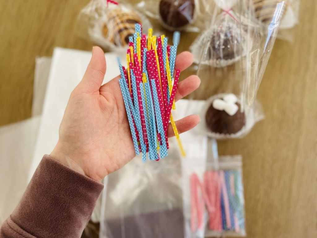 woman holding colorful zip ties that go around Cellophane Bags