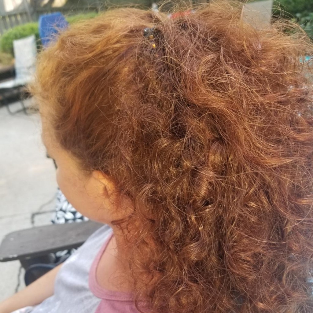 woman with curly hair wearing a banana clip