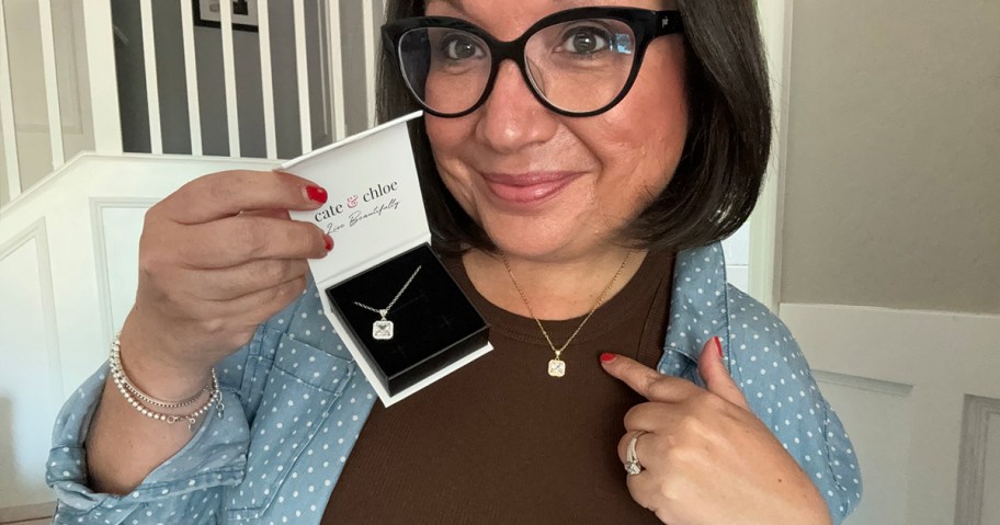 woman holding cate and chloe jewelry box with necklace and wearing another necklace