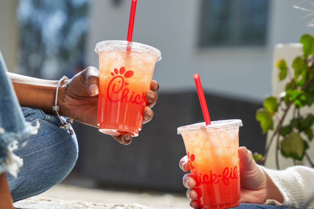 two hands holding drinks