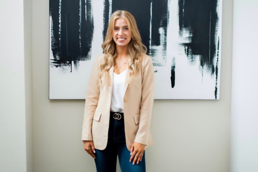 woman posing in front of modern artwork wearing cream colored notch collar blazer dupe