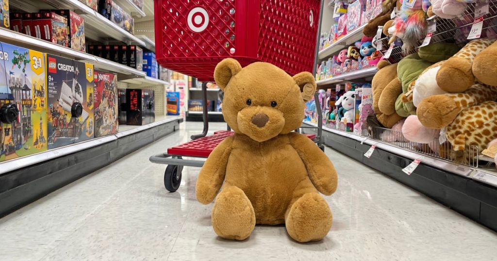 tan teddy bear in front of red cart 