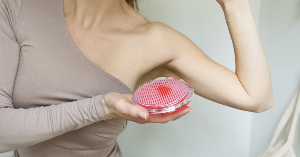 woman holding an exfoliating brush