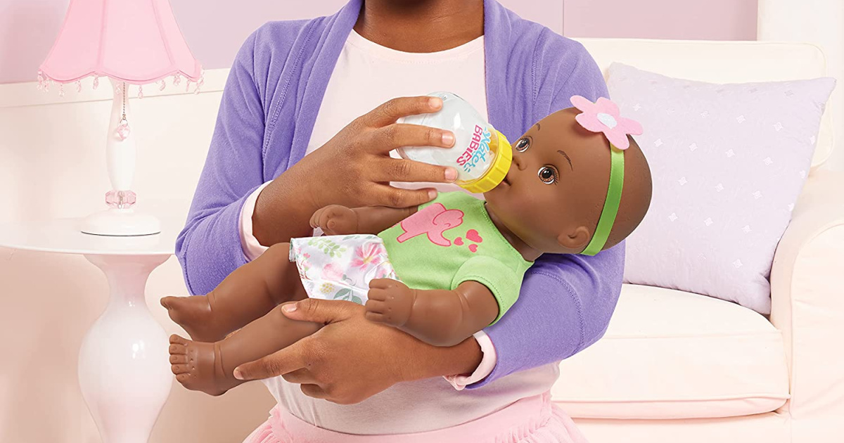 girl holding and feeding baby doll