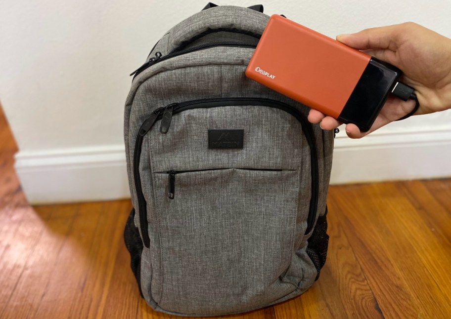 holding phone charger next to bag