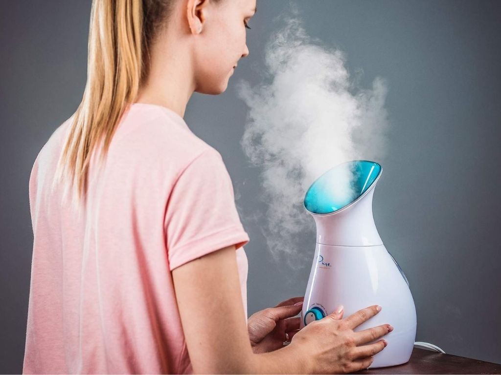 woman using facial steamer