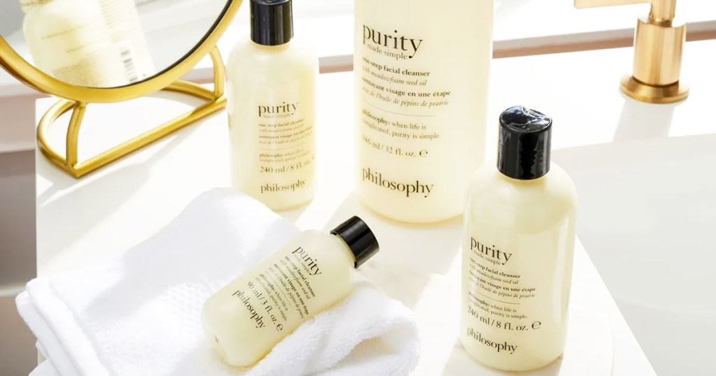 yellow bottles pf philosophy cleansers on bathtub edge