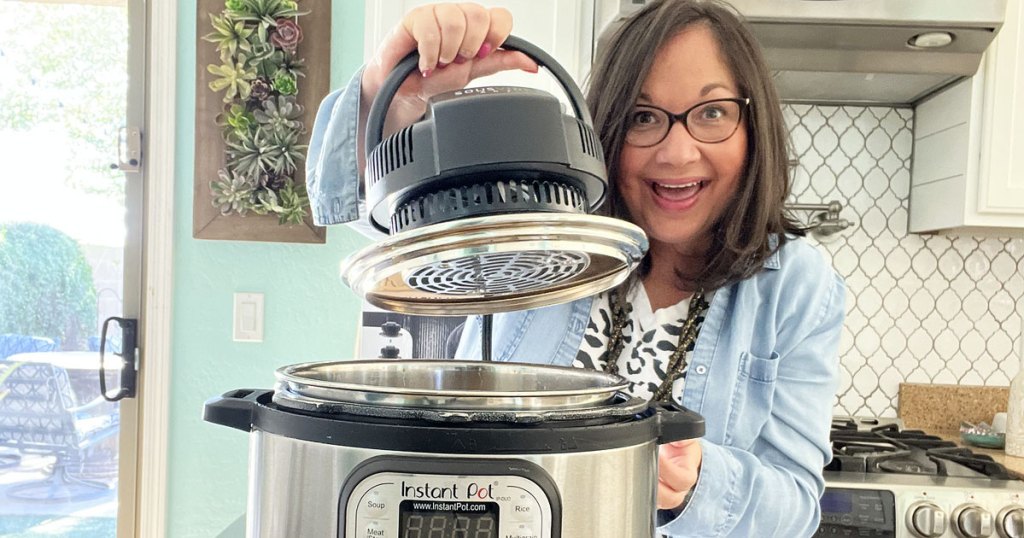 woman holding air fryer lid next to an instant pot