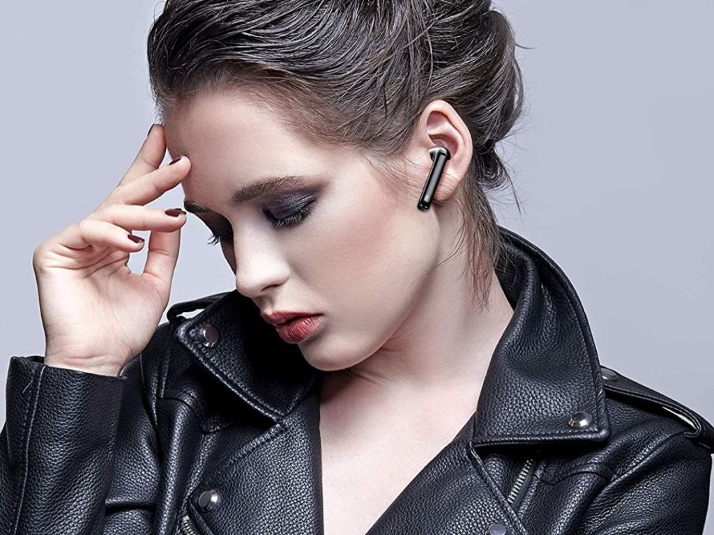 woman wearing black leather jacket with black Taotronics earbud in ear