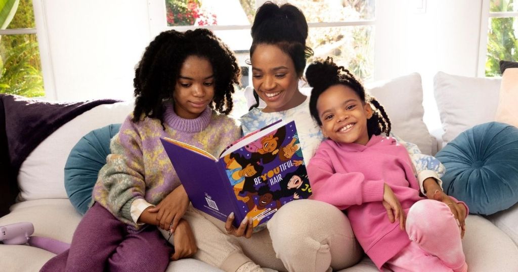 woman reading book to two girls