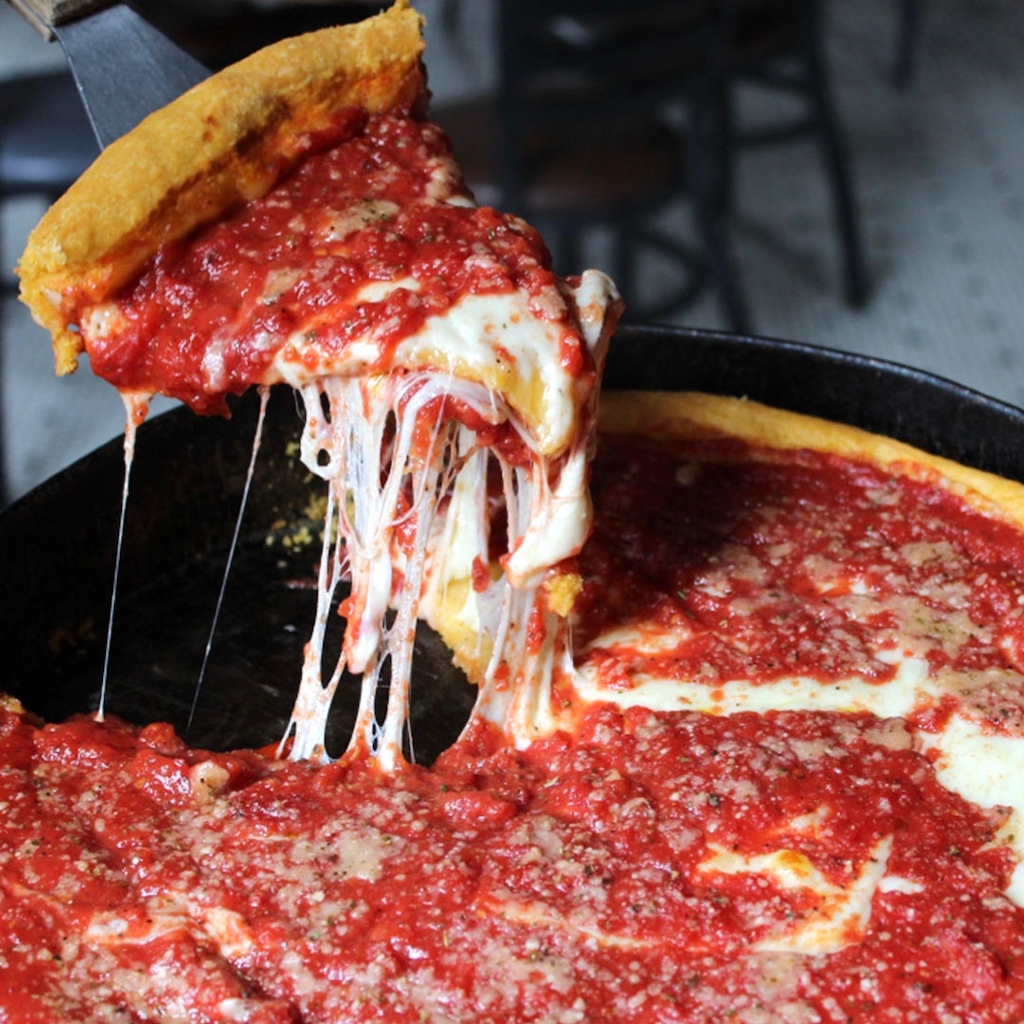 taking slice of deep dish pizza 