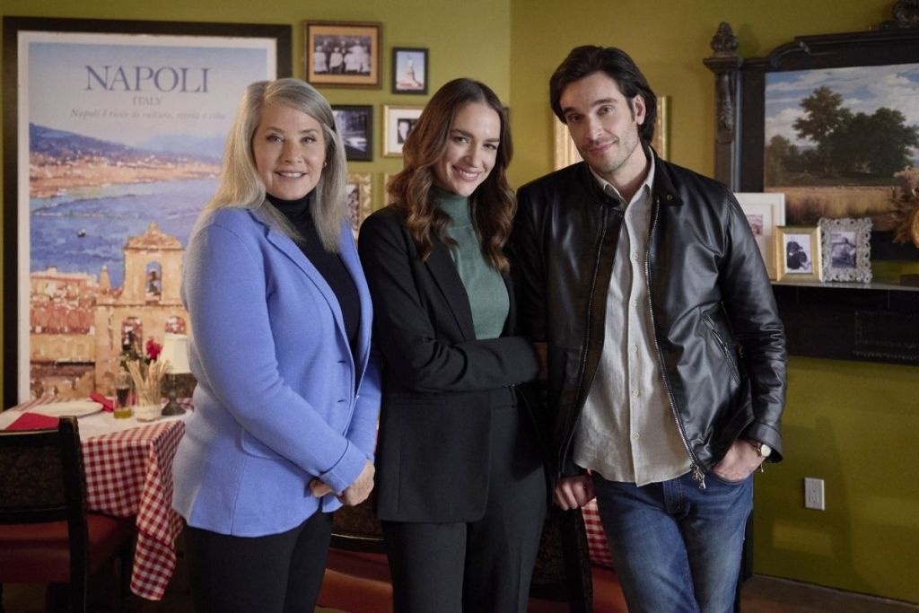 Two women and a man standing together in a house