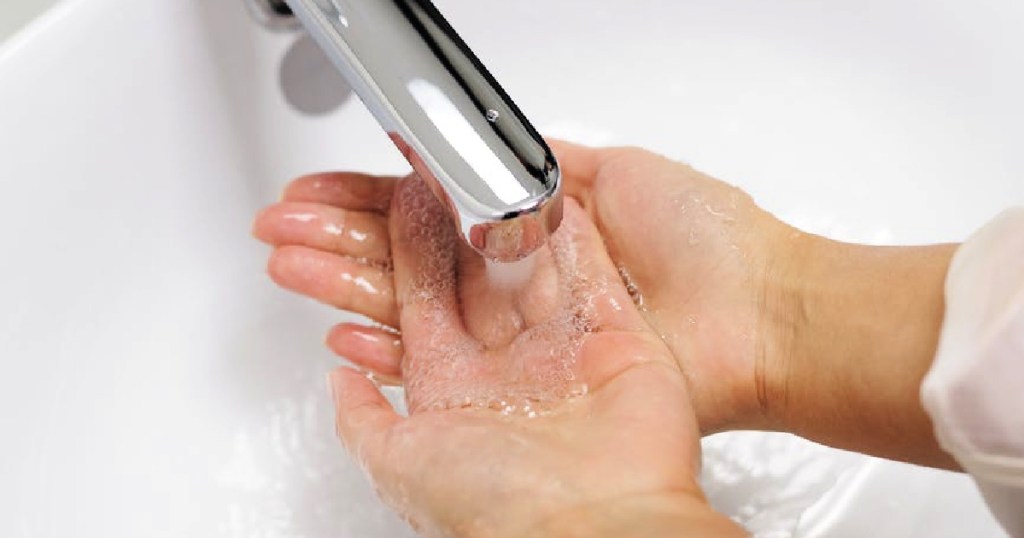 hands under water faucet