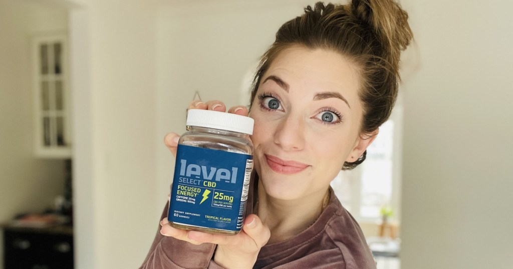 woman holding a bottle of level CBD gummies