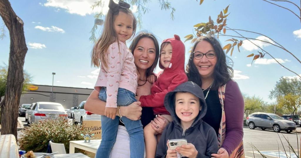 woman and children smiling standing outside 