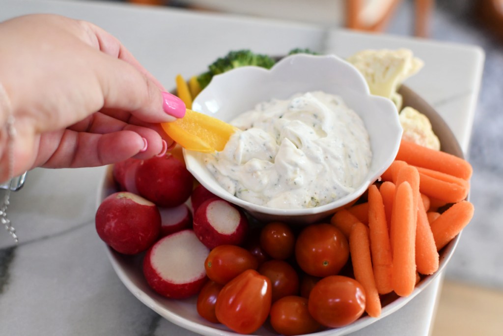 dipping a bell pepper in homemade ranch seasoning dip