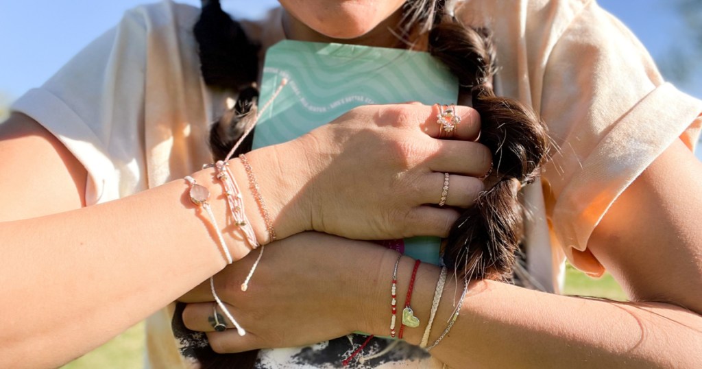 hands hugging Pura vida bracelet pack