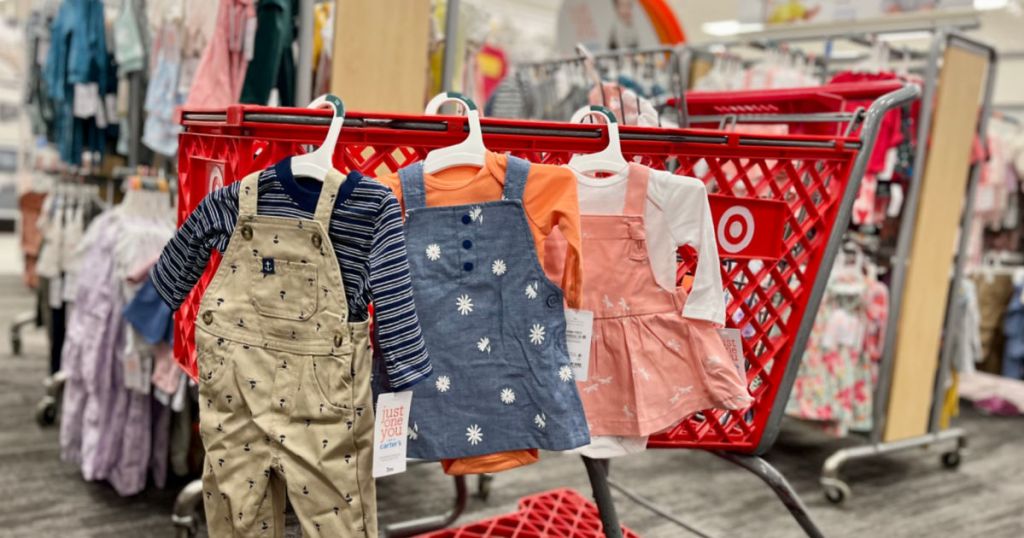 baby clothes hanging from red cart 