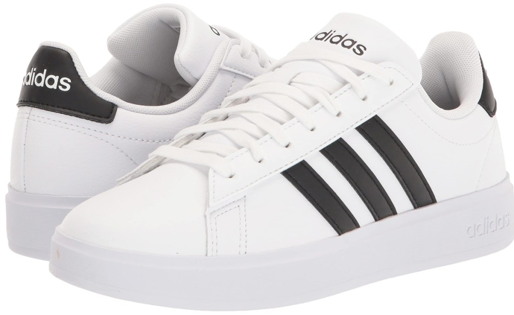 pair of white adidas sneakers with 3 black stripes