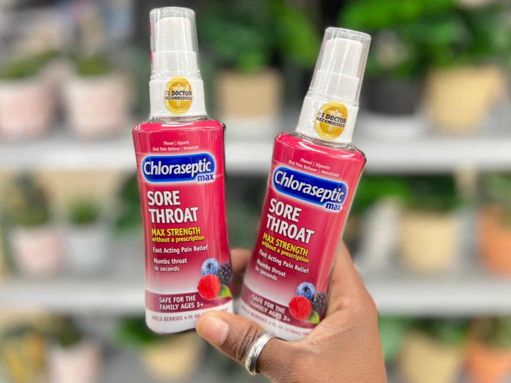 hand holding two bottles of sore throat spray