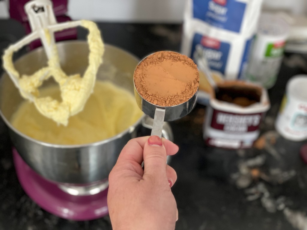 adding cocoa powder to a mixer 