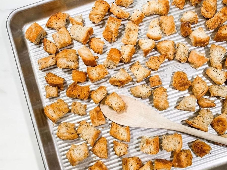 USA Pan Bakeware Half Sheet Pan with croutons on it
