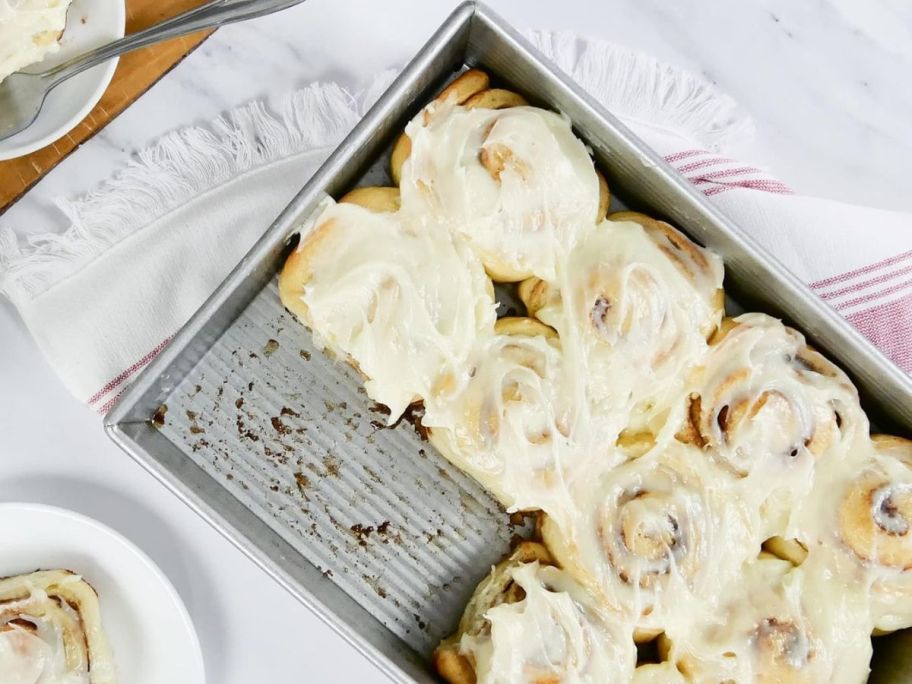 A USA Pan Bakeware Rectangular 9 x 13 Cake Pan filled with cinnamon rolls