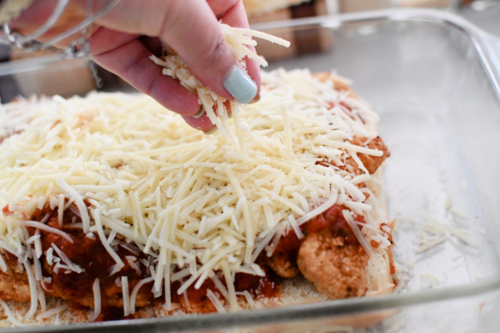 adding cheese to parmesan chicken before baking
