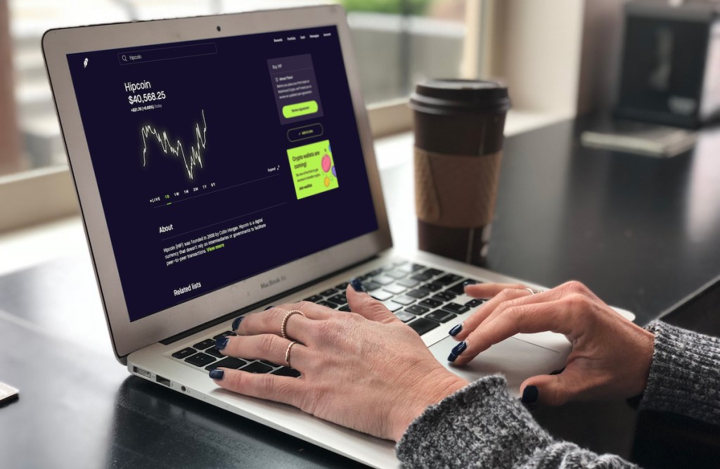 hands typing on laptop keyboard with hipcoin cryptocurrency on screen